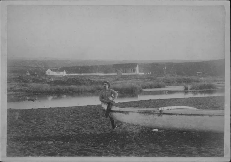 Historic photograph of Punaluʻu, Hawaiʻi Island circa 1890, showing early shoreline activity, canoe, and freshwater pond near the coast