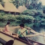 People paddling an outrigger canoe on freshwater lagoons at Punaluʻu Village during the Sea Mountain community era in Kaʻū, Hawaiʻi